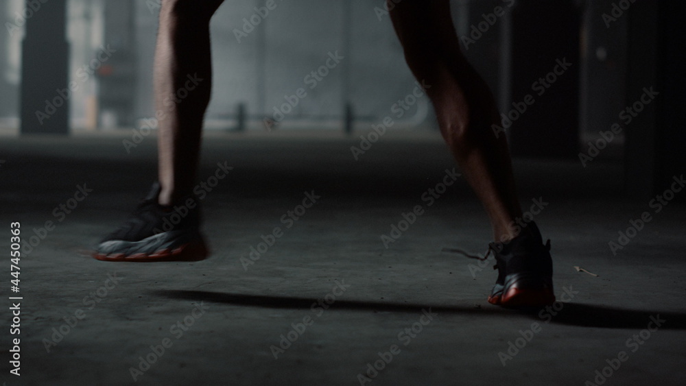 Sportsman exercising in loft building. Athlete moving feet during training