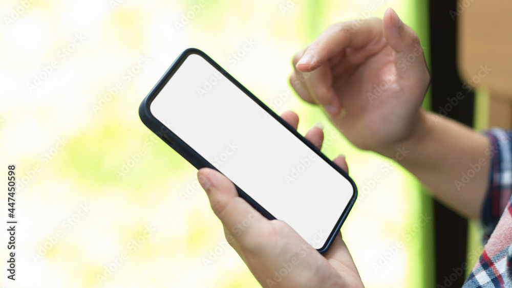 Smartphone with blank screen on female hand, female browsing internet