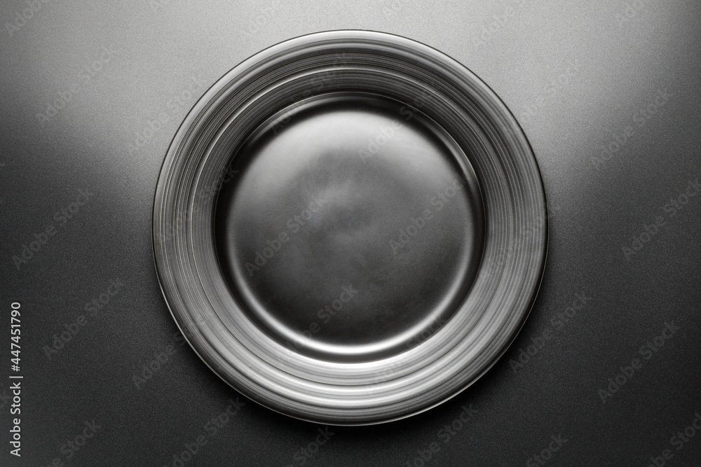 Empty black plate on black background. Top view. Empty black plate on black background. Top view.