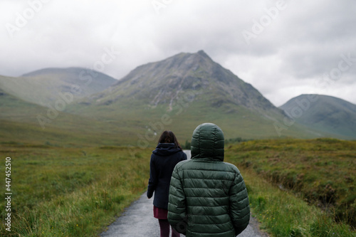 Couple of friends walking through the rain in Glen Etive, Scotland