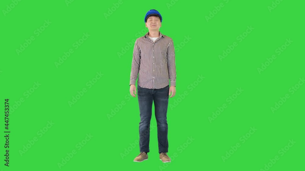 Engineer in a safety helmet smiling on camera on a Green Screen, Chroma Key. Engineer in a safety helmet smiling on camera on a Green Screen, Chroma Key.