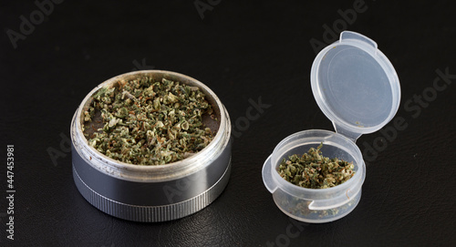 grinder with marijuana and transparent airtight container, black background