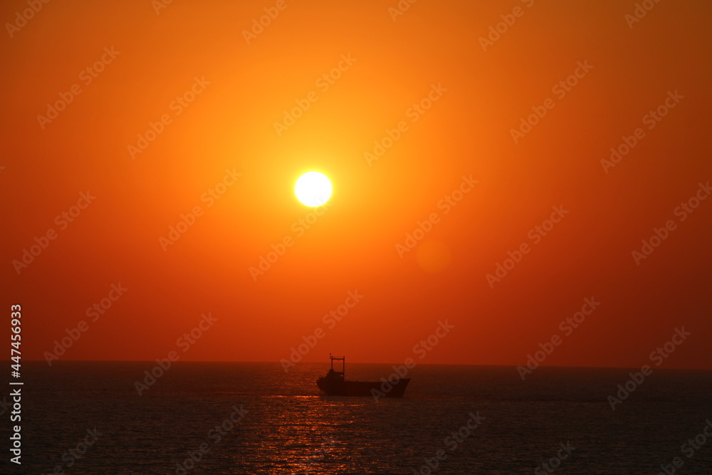 Sonnenuntergang mit Meer und bot im Vordergrund an der Ostsee Sonnenuntergang mit Meer und bot im Vordergrund an der Ostsee