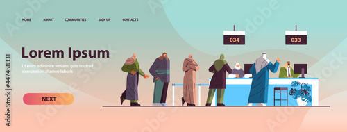 arab people looking at display number board in waiting room electronic queuing system queue management