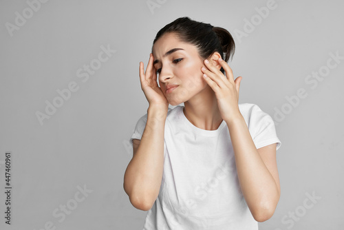 woman in white t-shirt holding face dissatisfaction problem isolated background