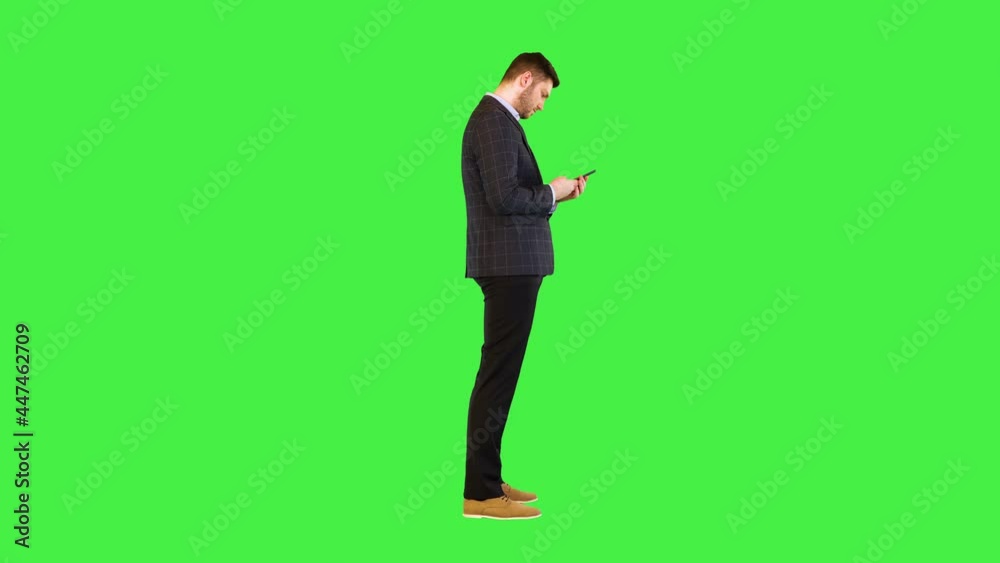 Young business man in suit use smartphone messaging, get good news online in smart phone and smile on a Green Screen, Chroma Key. Young business man in suit use smartphone messaging, get good news online in smart phone and smile on a Green Screen, Chroma Key.