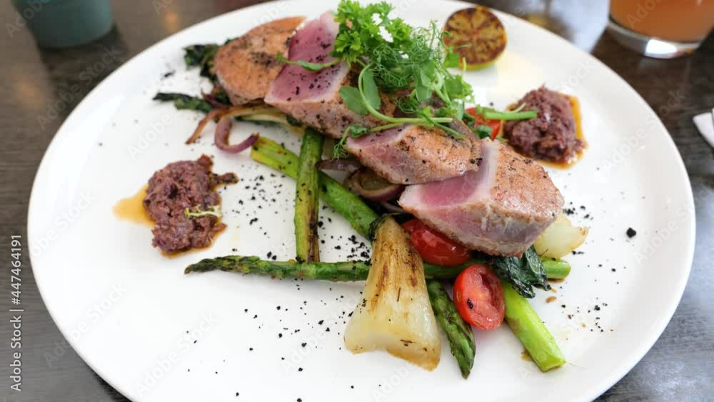delicious tuna steak with vegetables, greenery, asparagus, healthy seafood, fresh medium-rare grilled tuna fish delicious tuna steak with vegetables, greenery, asparagus, healthy seafood, fresh medium-rare grilled tuna fish