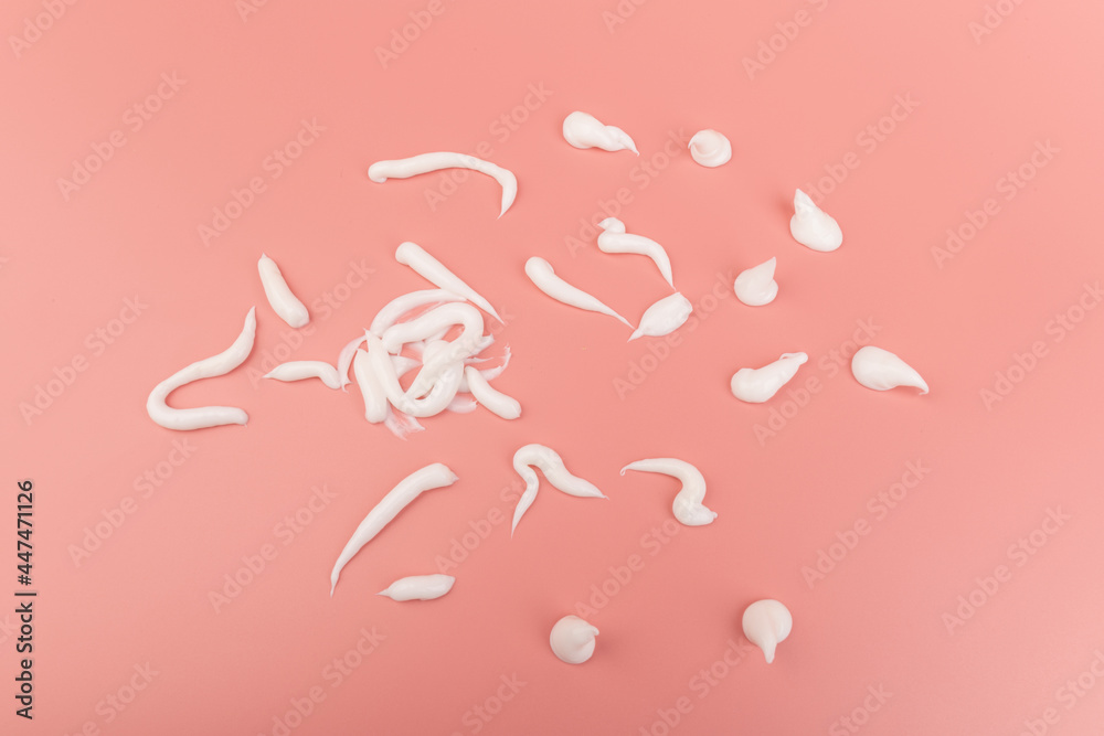 White cosmetic cream smear isolated on pink background. Skincare product creamy texture. White cosmetic cream smear isolated on pink background. Skincare product creamy texture.