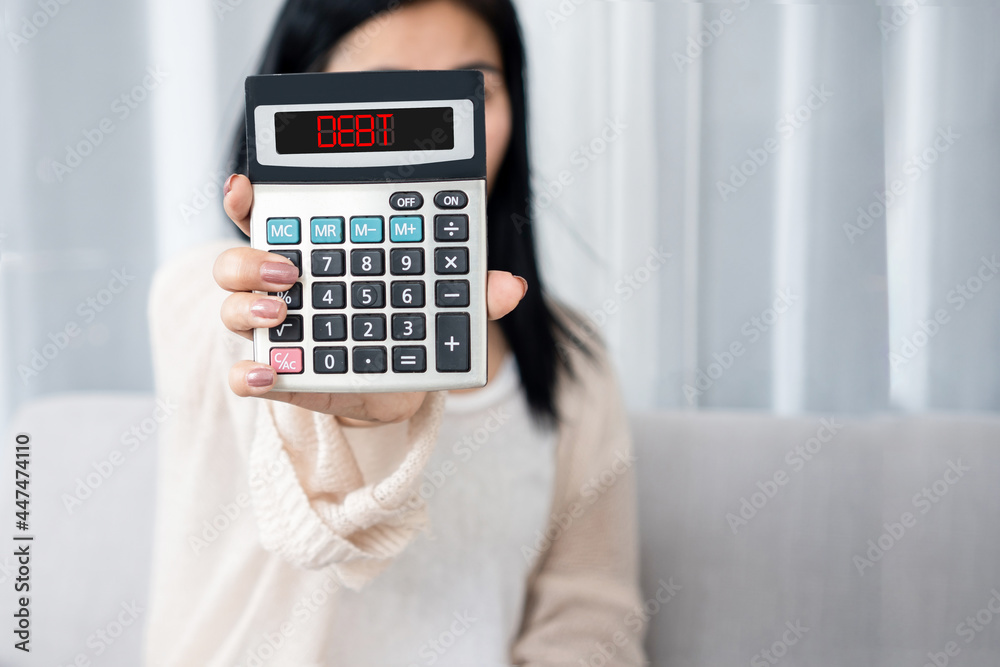 woman hand holding calculator showing word debt , bankruptcy, financial problem concept woman hand holding calculator showing word debt , bankruptcy, financial problem concept