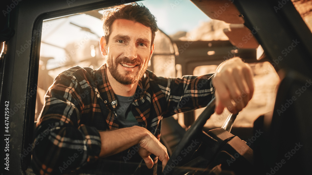 Desert Road Trip: Portrait of Handsome Male Explorer Looking out of Car Driver Window and Smiling. Adventurer Traveling through the Canyon on His Offroad SUV. Vacation Journey Through Marvelous Nature - obrazy, fototapety, plakaty 