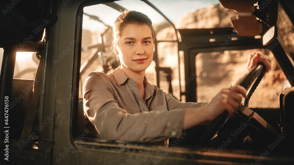 Desert Road Trip: Portrait of Beautiful Female Explorer Looking out of Car Driver Window and Smiling. Woman Adventurer Traveling through the Canyon on Her Offroad SUV. Journey Through Marvelous Nature