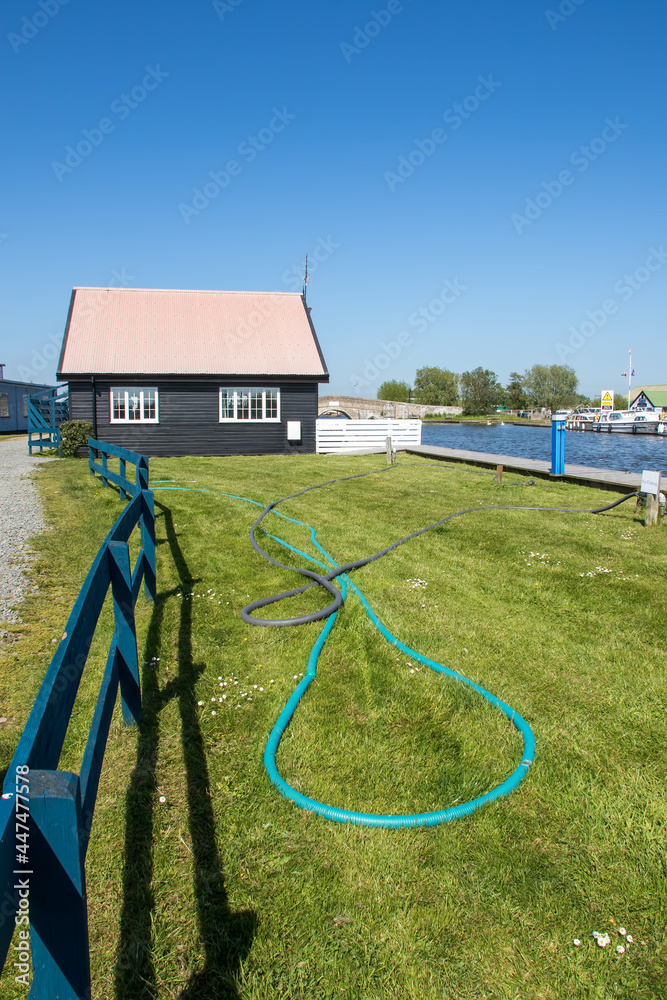 Hose pipes on a lawn. Beautiful painterly riverside landscape image