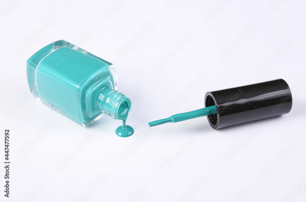 Bottle with blue spilled nail polish isolated on white background Bottle with blue spilled nail polish isolated on white background