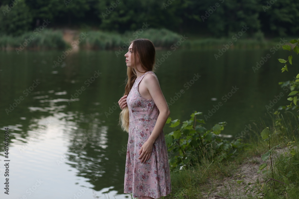 Long haired woman in pink dress standing near water Long haired woman in pink dress standing near water