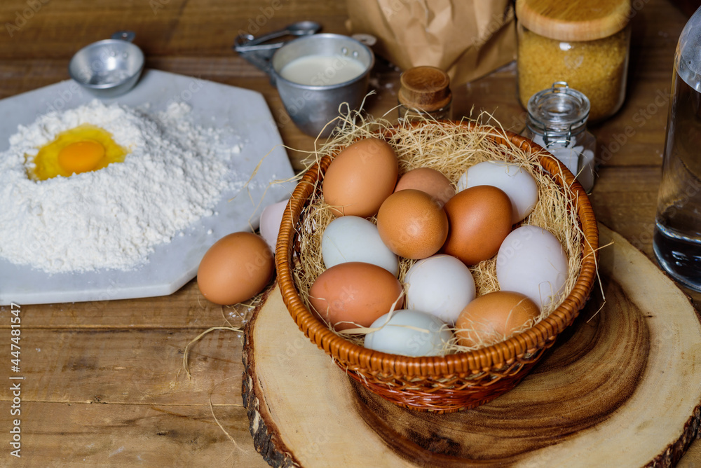 A lot of eggs put in the basket and place on the wooden table.. A lot of eggs put in the basket and place on the wooden table..