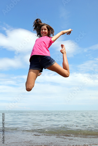 girl with brown long hair jumping in the air symbol of happiness and joy