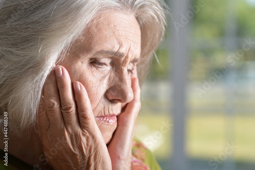 Portrait of sad senior woman with headache