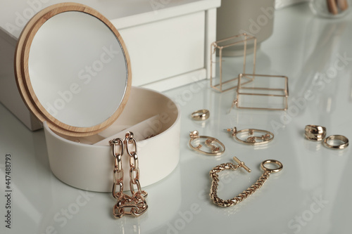 Papier peint Jewelry box with mirror and stylish golden bijouterie on white dressing table
