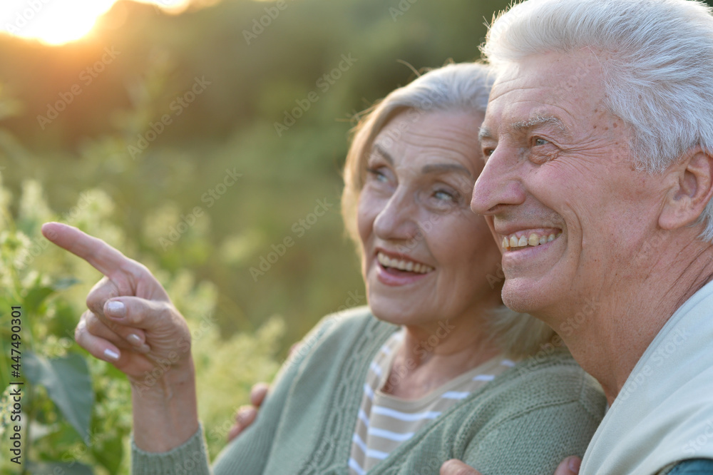 Fototapeta premium senior couple posing in the park, man pointing with finger