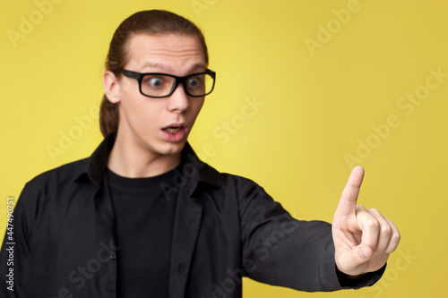 young man in glasses touching virtual screen