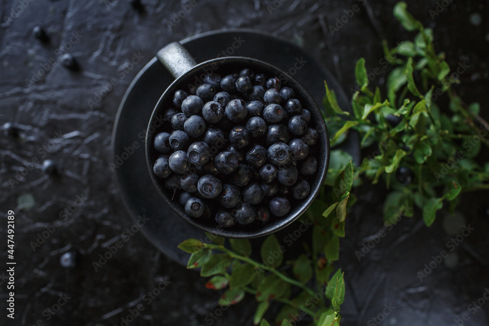 blueberries in a cup, black background blueberries in a cup, black background