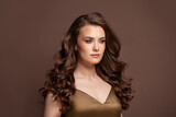 Brunette model woman with curly hairstyle on dark brown background