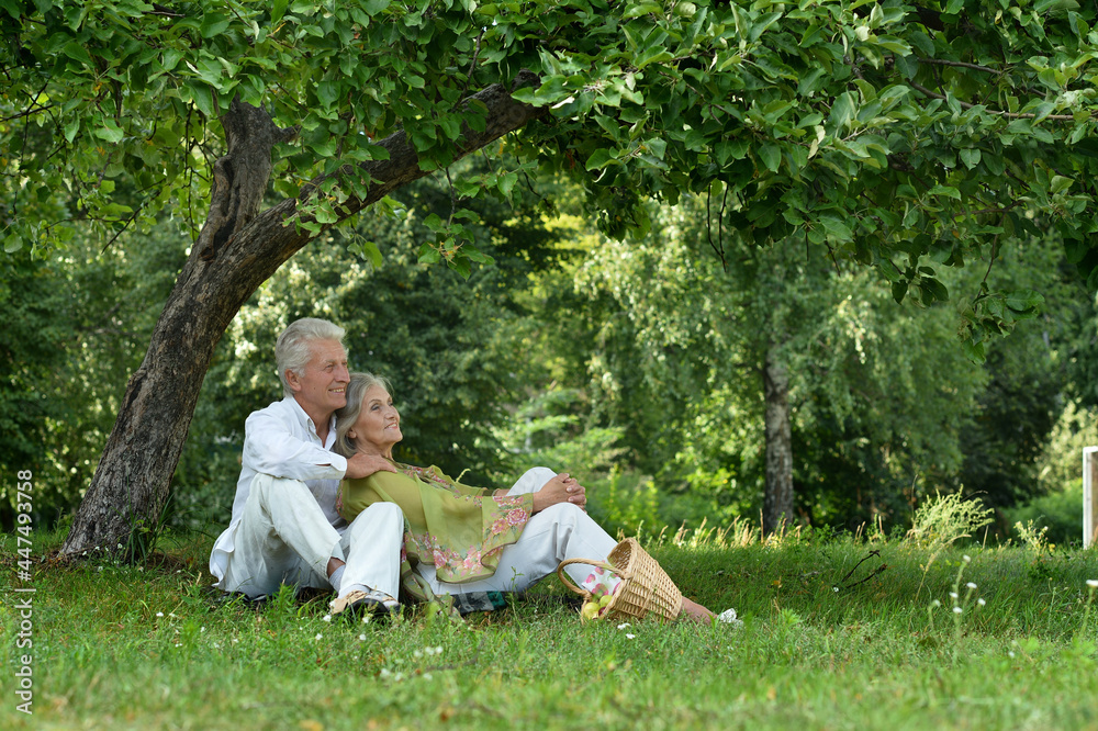 Senior couple sitting on the grass in the park Senior couple sitting on the grass in the park