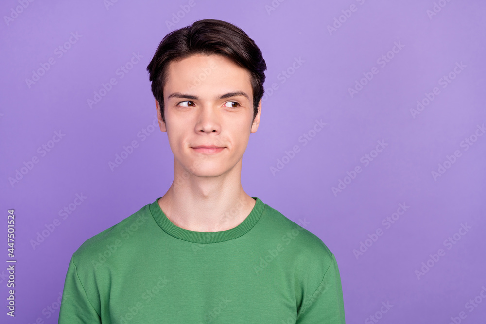 Photo of young handsome guy happy positive smile curious dream think look empty space isolated over violet color background Photo of young handsome guy happy positive smile curious dream think look empty space isolated over violet color background