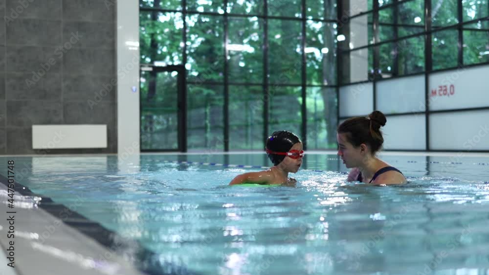 swimming lesson class water instructor coach teaching little child kid to swim dive float in the swimming pool. lifestyle education sport healthy concept