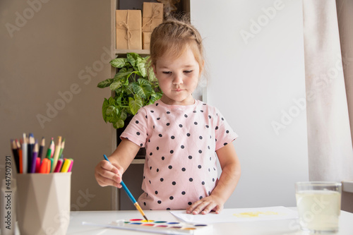 A little girl paints at home. Concept creativity.