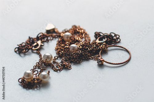 cheap jewelry chain bracelet and ring blackened from water on white background.