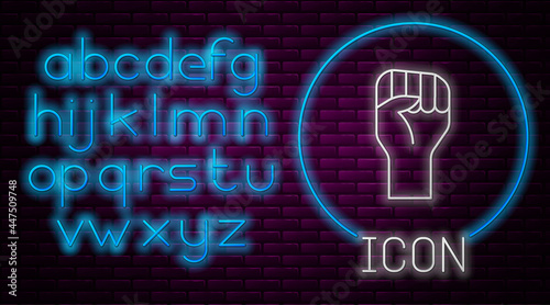 Glowing neon line Raised hand with clenched fist icon isolated on brick wall background. Protester raised fist at a political demonstration. Empowerment. Neon light alphabet. Vector
