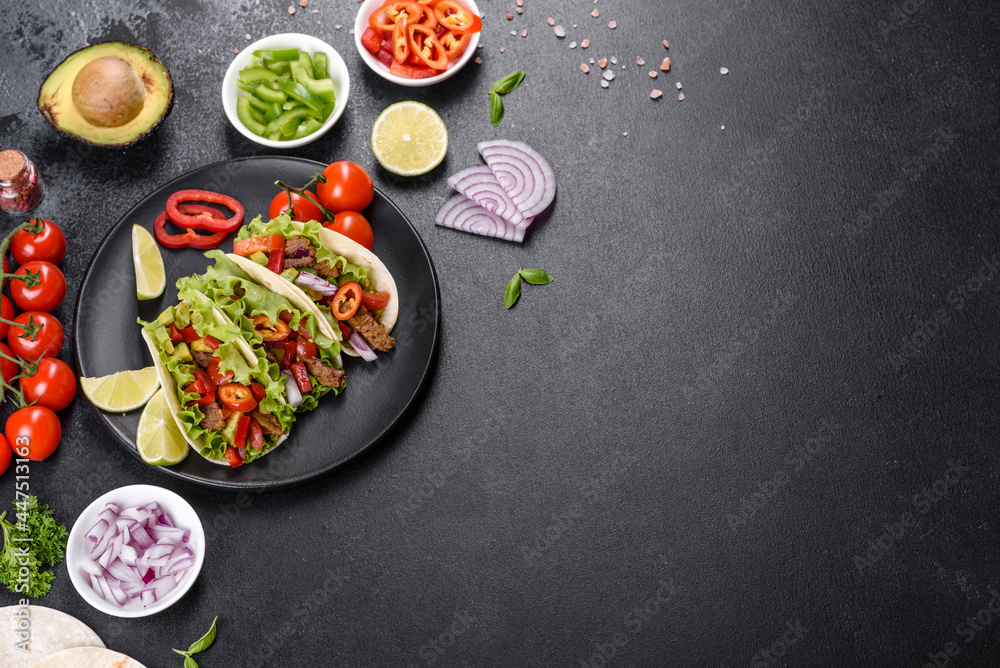 Mexican tacos with beef, tomatoes, avocado, onion and salsa sauce