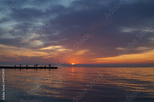 Dawn over the Black Sea and the pier with people who meet the dawn.