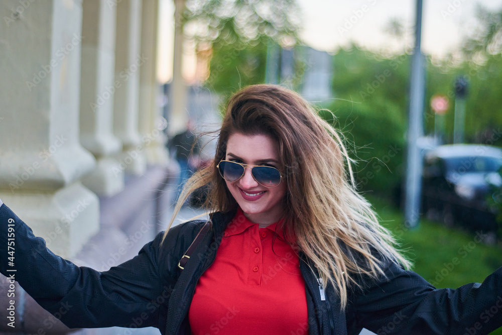 Young woman in red polo shirt and sunglasses is smiling with arms spreading out Young woman in red polo shirt and sunglasses is smiling with arms spreading out