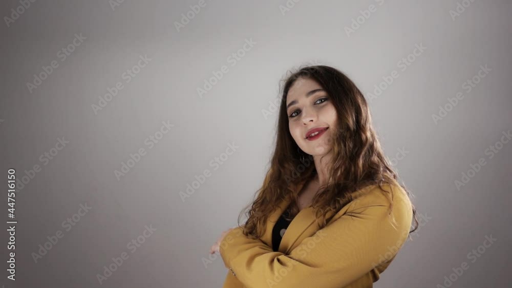 Isolated portrait on white background of young attractive woman who is posing in slowmo. Caucasian lady is smiling and moving. She is touching her long hair and face. Concept of fashion and model job. Isolated portrait on white background of young attractive woman who is posing in slowmo. Caucasian lady is smiling and moving. She is touching her long hair and face. Concept of fashion and model job.