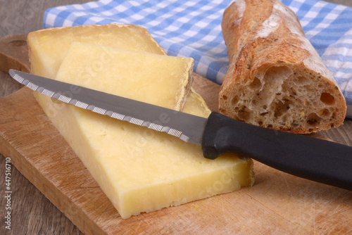 Morceaux de fromage de Laguiole avec un couteau à côté d'un morceau de pain en gros plan