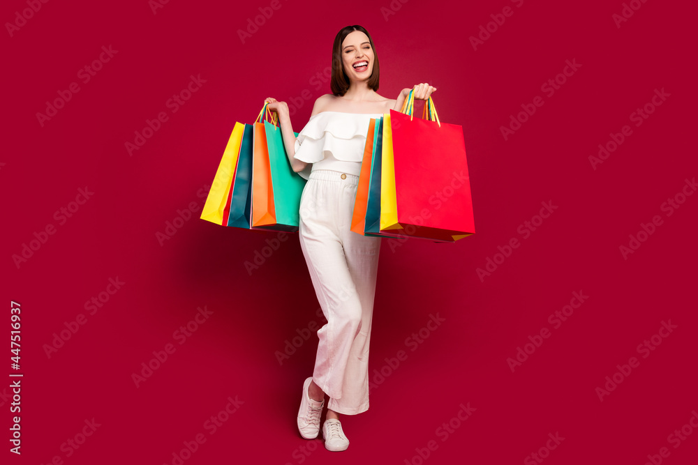 Full body photo of cool brown hairdo millennial lady with bags wear top pants isolated on red background