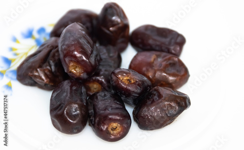 A bunch of dried black dates fruit in a plate