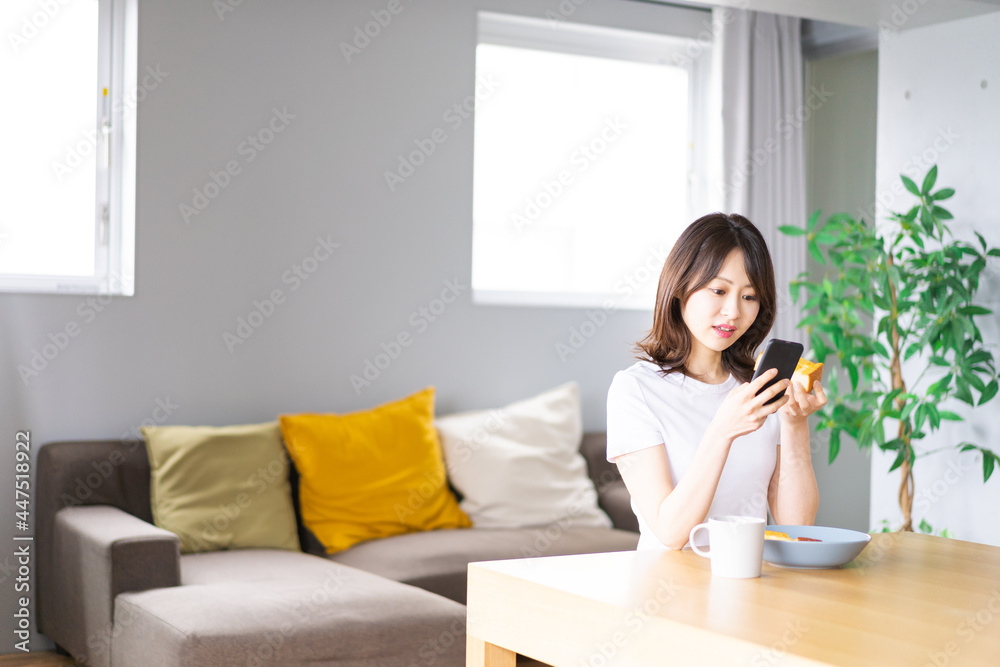 自宅で朝食を食べる若い女性 自宅で朝食を食べる若い女性