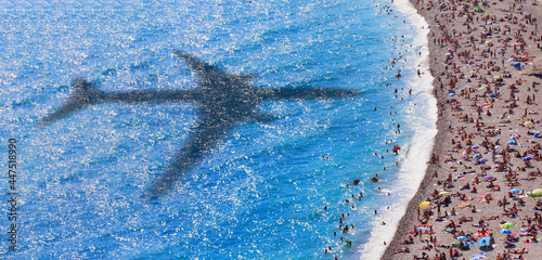 Waves on the beach with shadow of commercial airplane flying above beautiful tropical beach