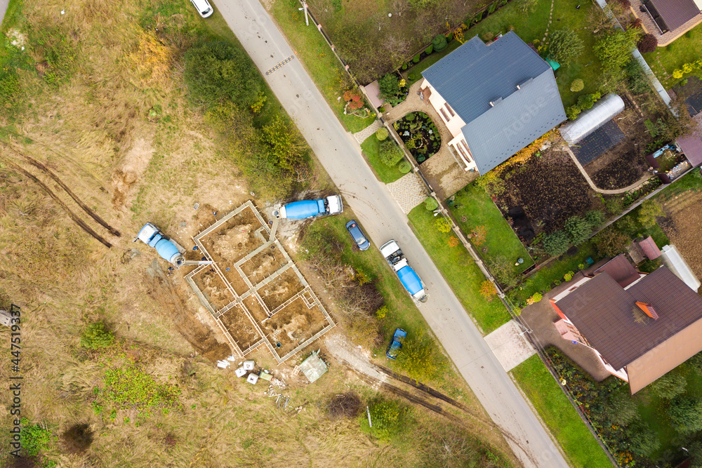 Top down aerial view of construction works of new house concrete foundation in rural residential area.