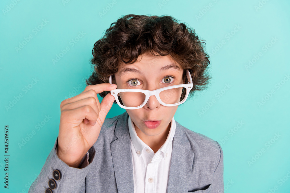 Photo of adorable impressed school boy wear grey jacket arm spectacles big eyes isolated turquoise color background Photo of adorable impressed school boy wear grey jacket arm spectacles big eyes isolated turquoise color background