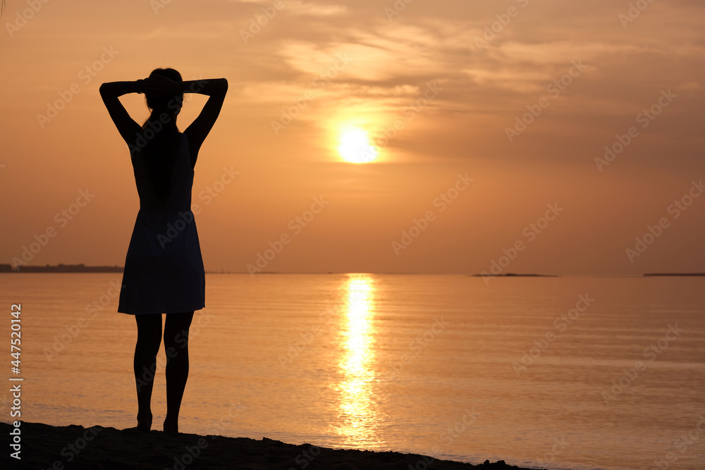Young woman relaxing alone on ocean sand shore by seaside enjoying warm tropical evening.