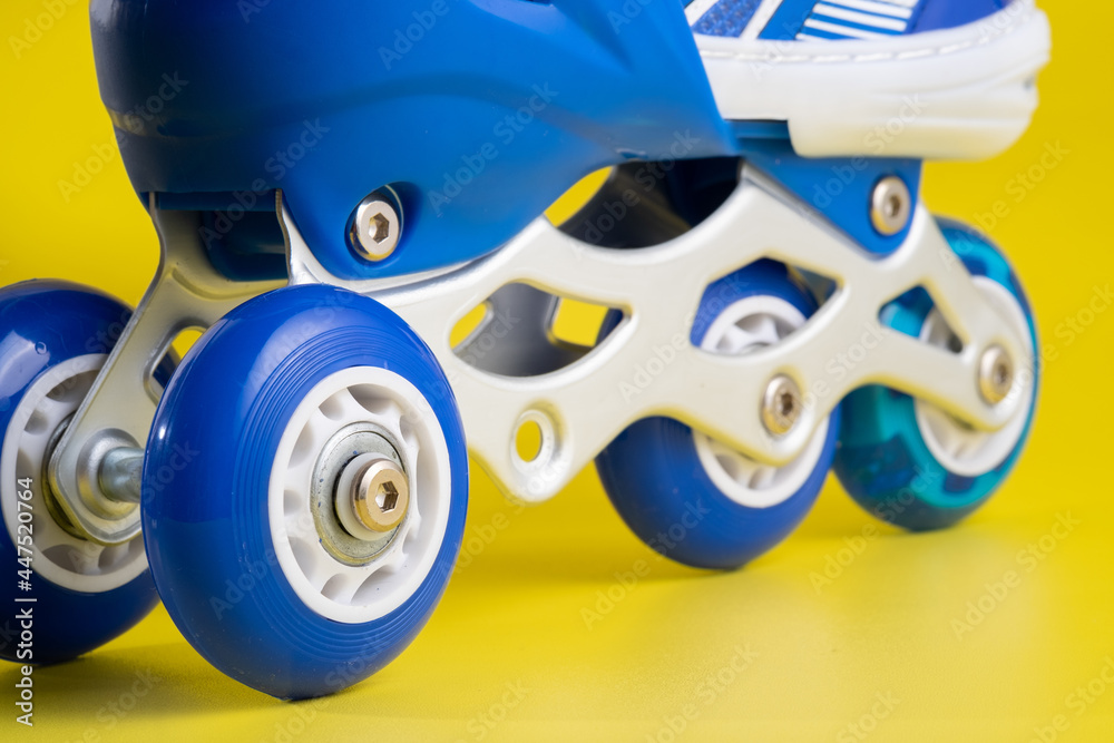 Fototapeta premium Blue skates shoes on yellow background
