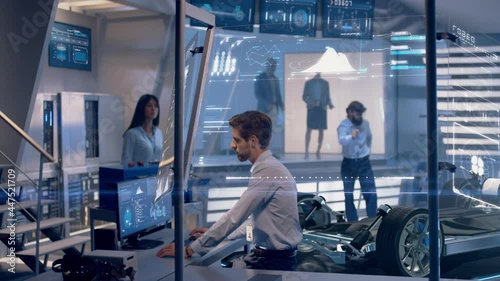 Engineer shows Client a Concept of Electric Vehicle. Automotive engineers analyzing design of Electric Car using augmented holographic technology. High-tech industrial facility.