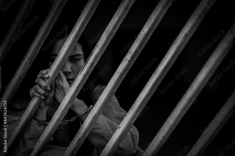 Portrait of women desperate to catch the iron prison,prisoner concept,thailand people,Hope to be free,If the violate the law would be arrested and jailed. Portrait of women desperate to catch the iron prison,prisoner concept,thailand people,Hope to be free,If the violate the law would be arrested and jailed.