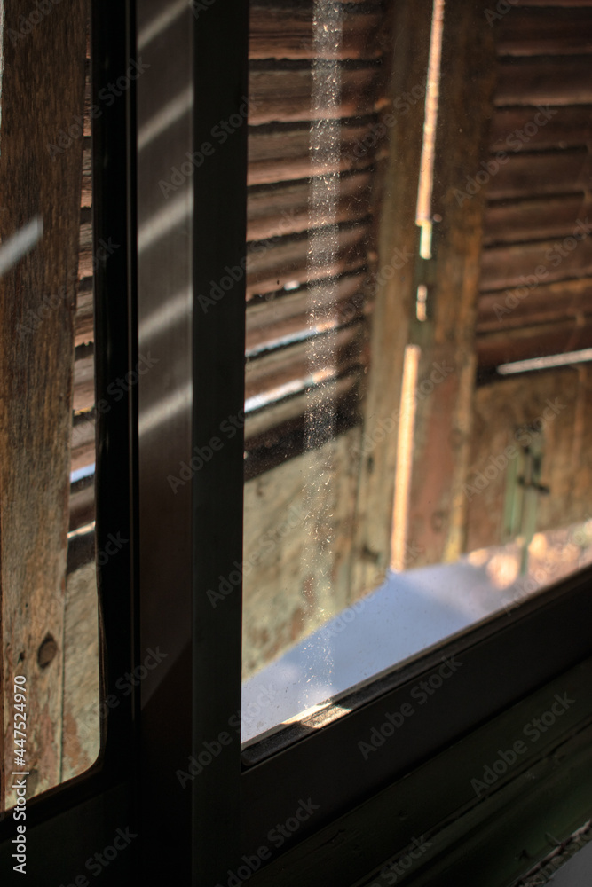 ventana con persiana de madera con luz del sol