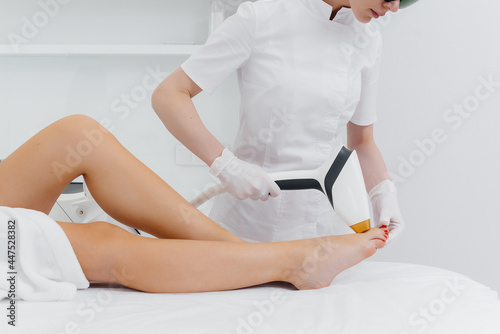 A beautiful young girl will undergo laser hair removal with modern equipment in a Spa salon. Beauty salon. Body care