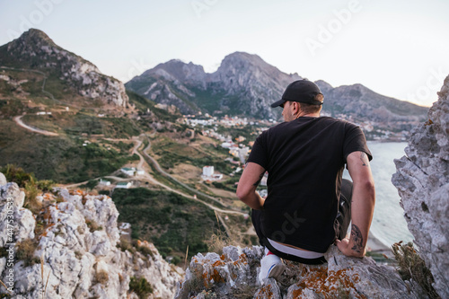 Un hombre excursionista mirando el atardecer junto a la frontera de Benzú photo